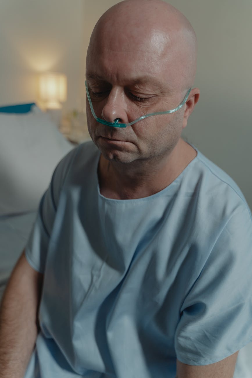 close up photo of a sick man wearing nasal cannula