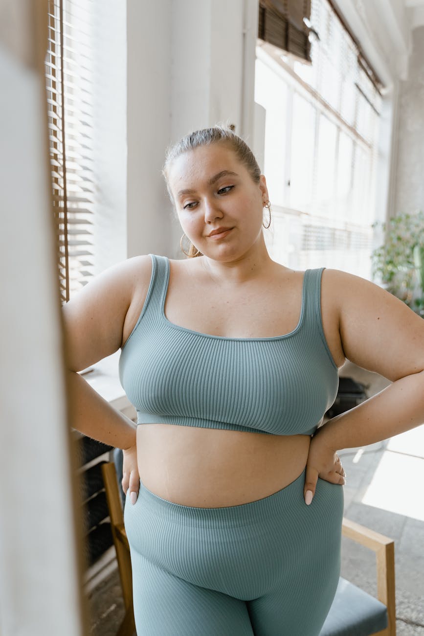 woman in teal sports bra and brown leggings